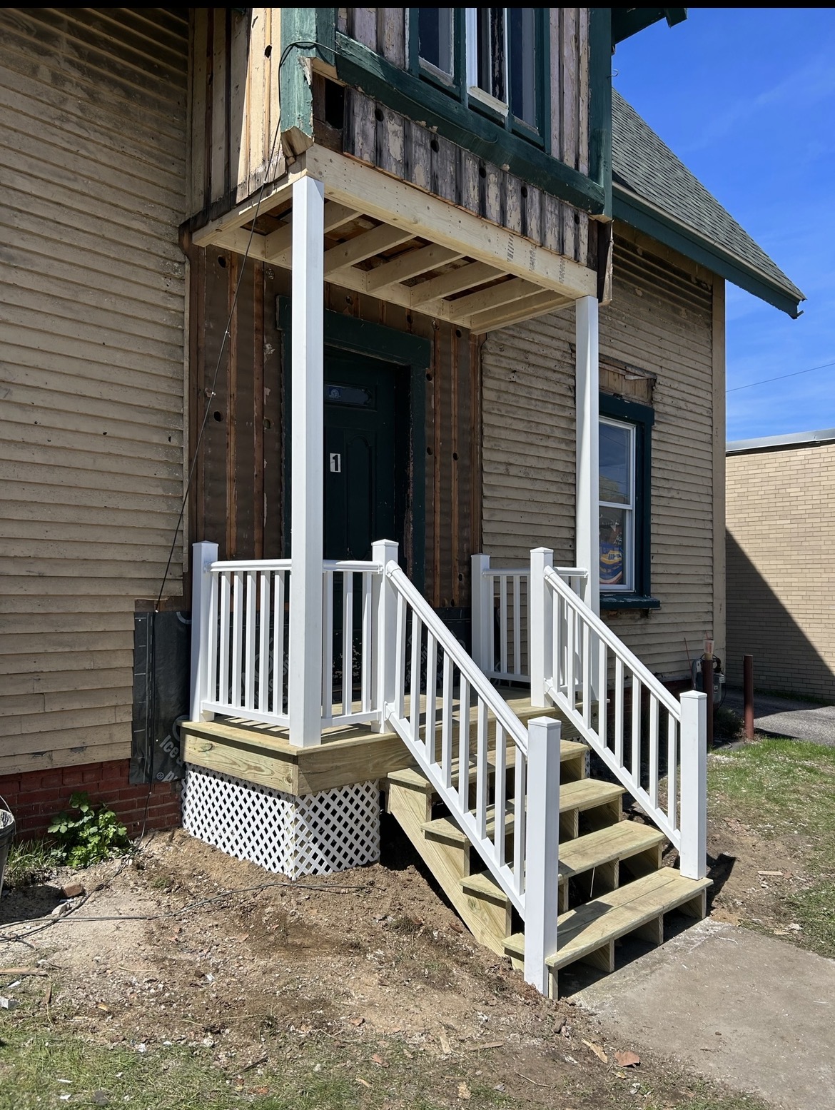 New front entry steps and porch with white railings, by Three Lakes Builders LLC
