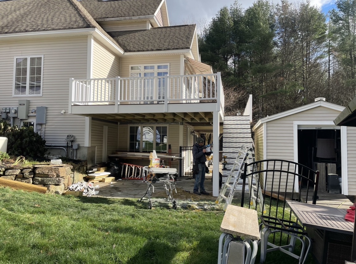 Backyard deck and stairs under construction on a two-story home, by Three Lakes Builders LLC