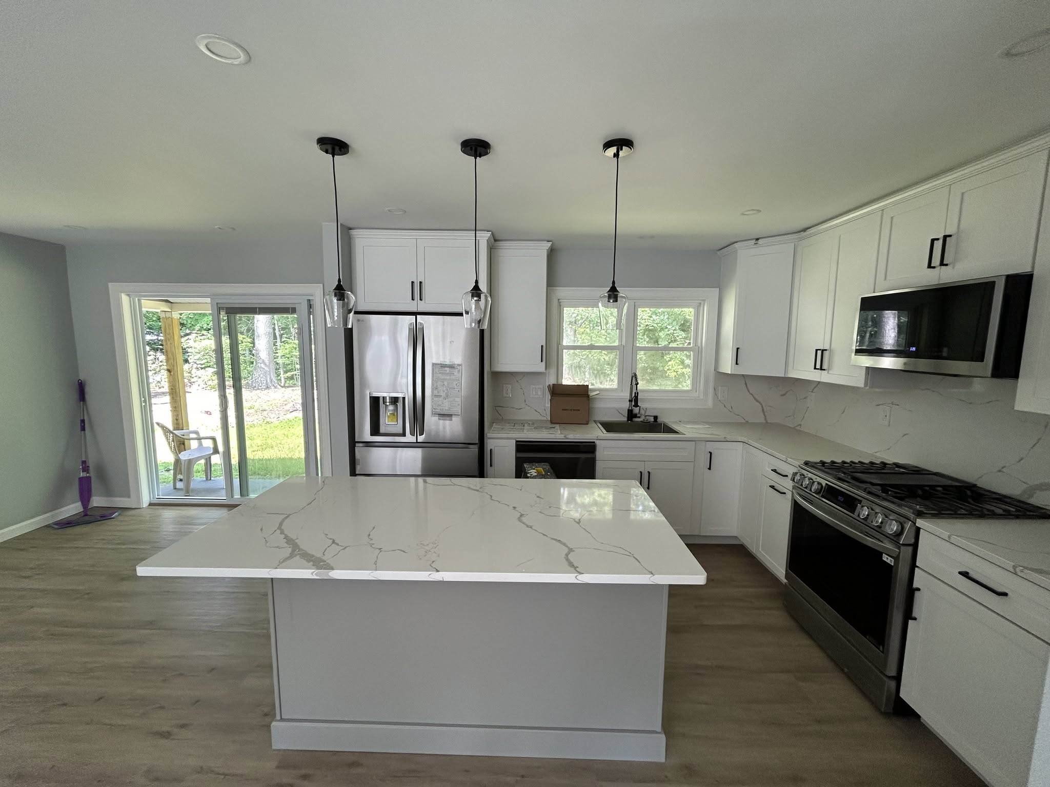 Bright kitchen with white cabinets and island, posted by Three Lakes Builders LLC
