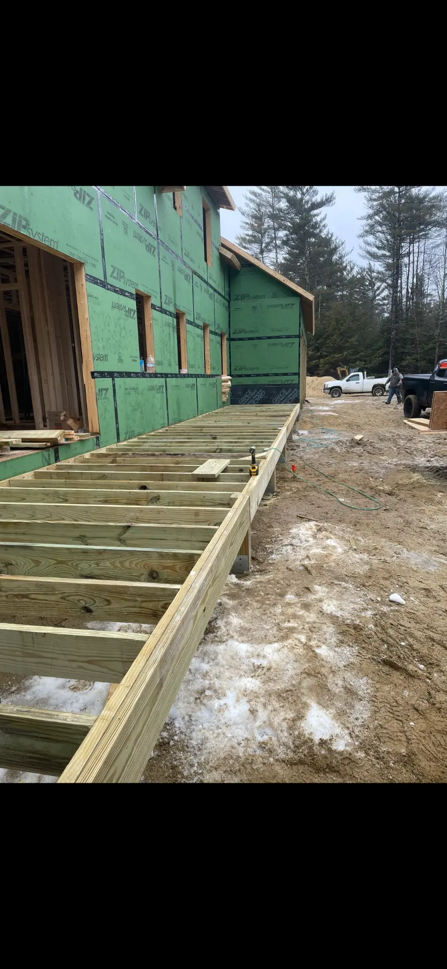 Deck framing along the side of a home under construction, by Three Lakes Builders LLC