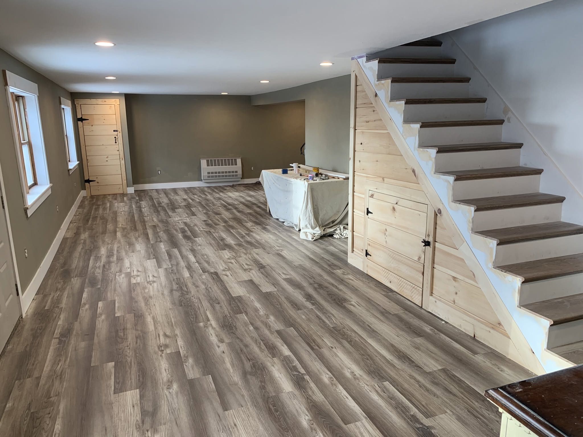 Interior living space with wood-look floor and open staircase, posted by Three Lakes Builders LLC