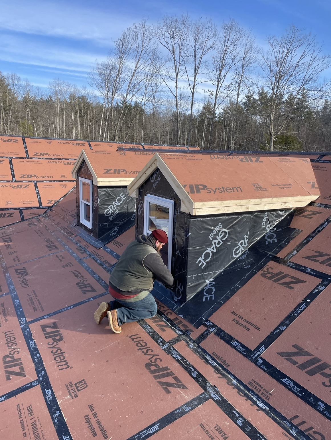 Dormers being built on a roof with protective underlayment, by Three Lakes Builders LLC