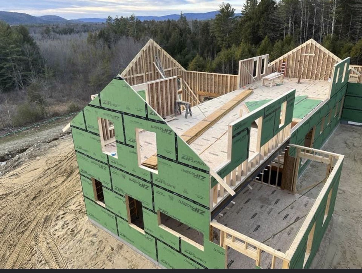 Aerial view of a new home being framed with green sheathing, by Three Lakes Builders LLC
