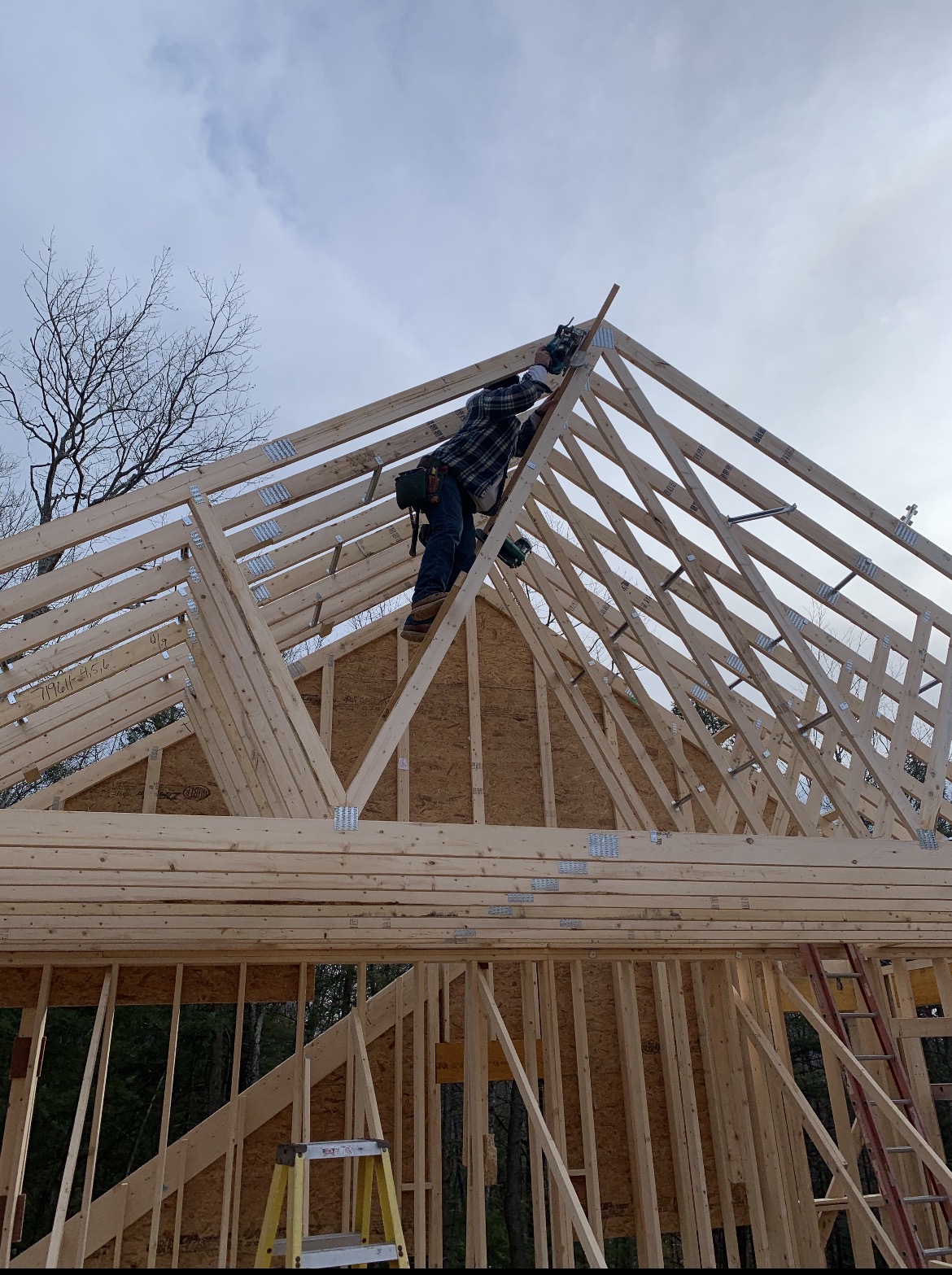 Roof trusses being installed on a new home frame, by Three Lakes Builders LLC