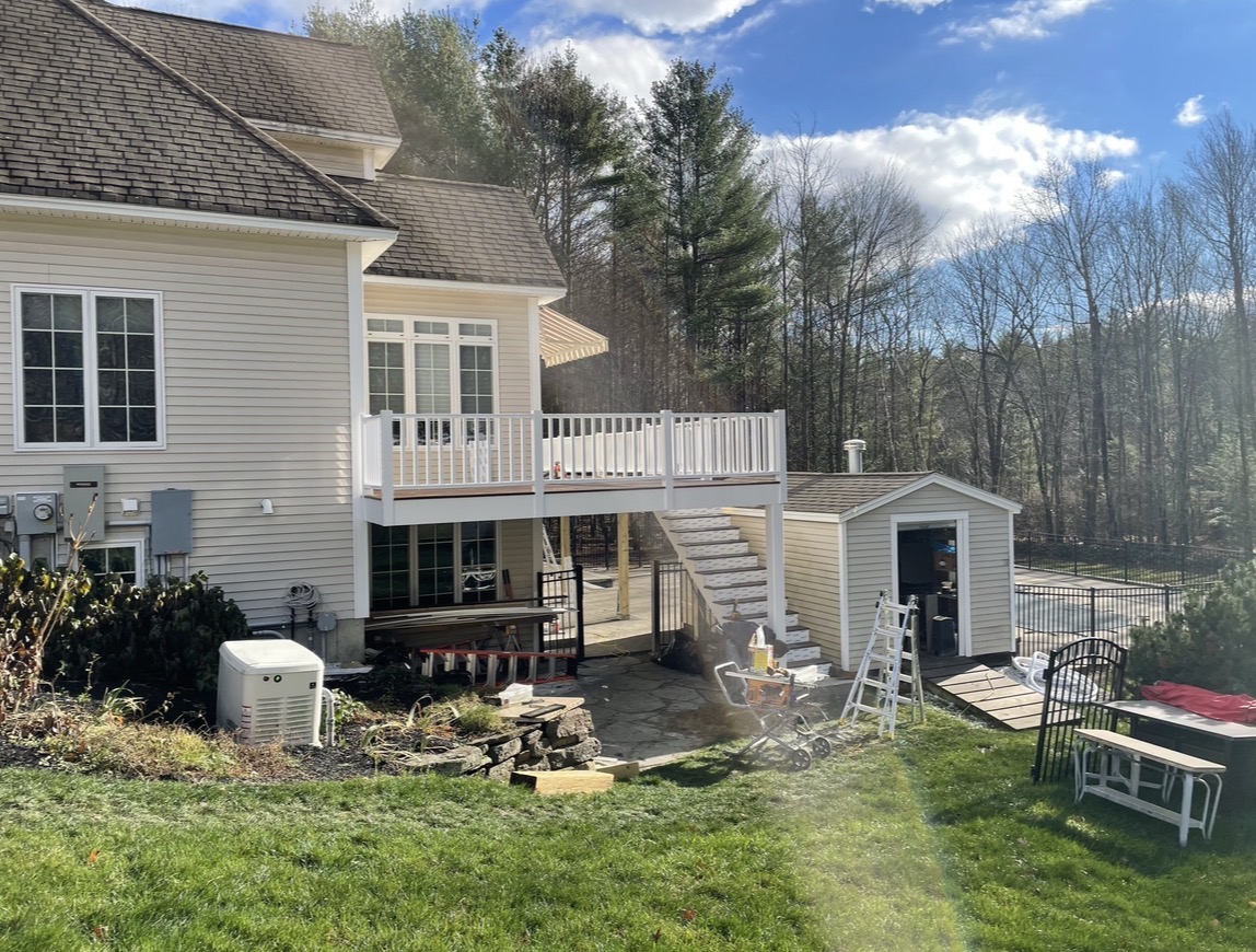 Completed backyard deck with white railings and stairs, by Three Lakes Builders LLC